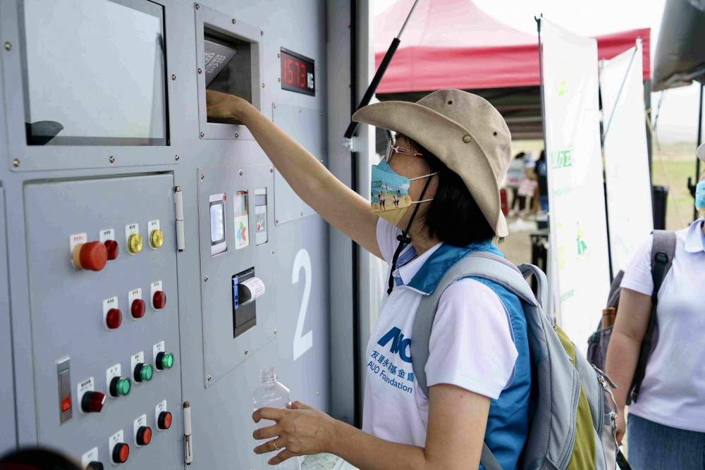 志工們將拾起的寶特瓶投入「好歸塑專車」，讓廢棄塑料空瓶可以直接粉碎、縮小體積，未來將可再製成購物袋、寶特衣、悠遊卡等生活用品